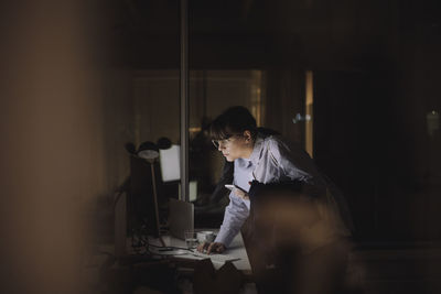 Businesswoman working on computer last minute in office at night