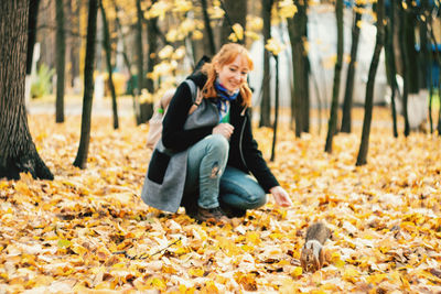 Full length of man sitting on mobile phone in forest