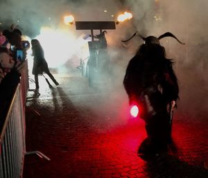 People on illuminated street at night