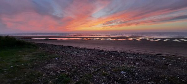 Scenic view of beach against sky during sunset