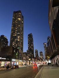 Low angle view of illuminated buildings against sky at night in toronto