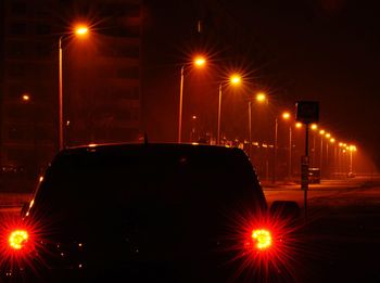 Illuminated street lights in city at night