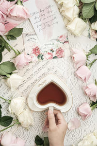 Cropped hand of woman holding gift on table