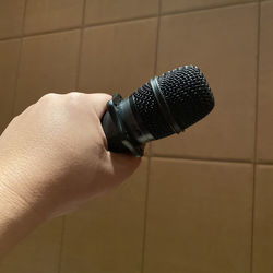 Close-up of hand holding camera on tiled floor