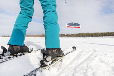 Low section of man skiing on snow covered field