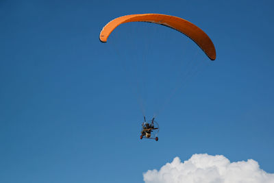 Low angle view of person paragliding against sky