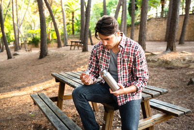 Woman sitting on bench in park