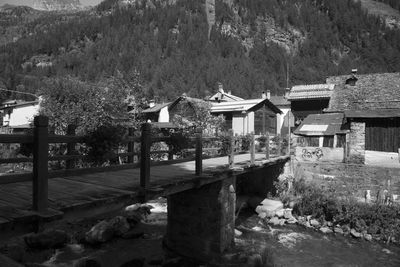 Houses by trees and buildings against mountain