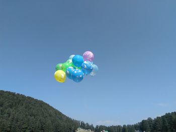 Low angle view of balloons against blue sky