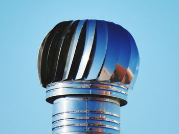 Low angle view of metal against blue sky