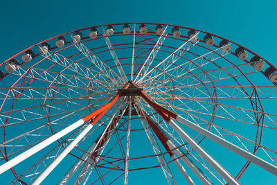 Low angle view of ferris wheel against blue sky