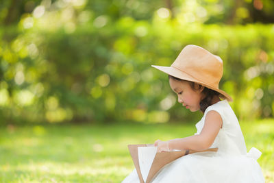 Side view of woman reading book