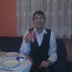 Portrait of a young man drinking glass on table