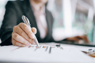 Midsection of woman holding hands on table