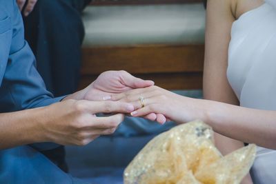 Midsection of couple holding hands