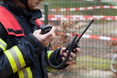 Firefighter standing with walkie-talkie outdoors