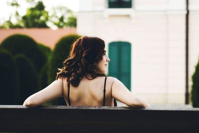 Rear view of woman sitting outdoors