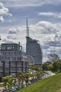 Buildings in city against cloudy sky