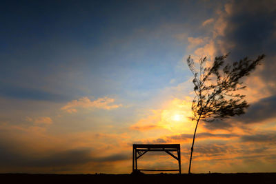 Low angle view of silhouette chair against sky during sunset