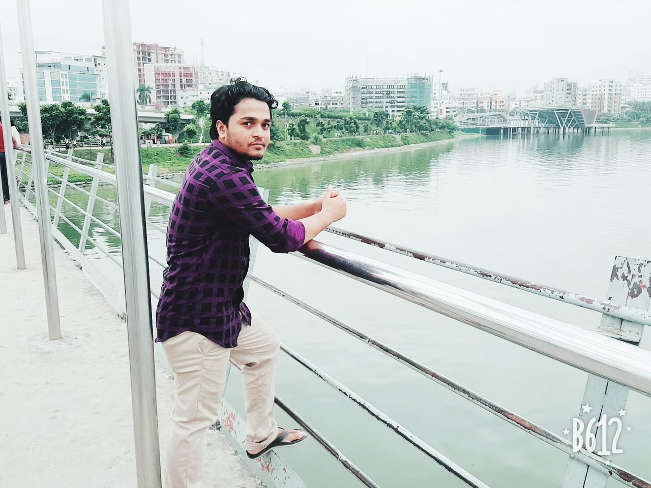 PORTRAIT OF MATURE MAN STANDING AGAINST RAILING