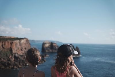 Rear view of woman looking at sea against sky