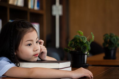 Girl with book on table at home
