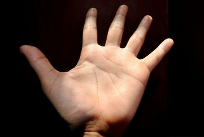 Close-up of human hand against black background
