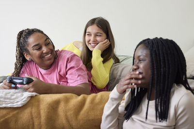 Teenage friends playing games together at home