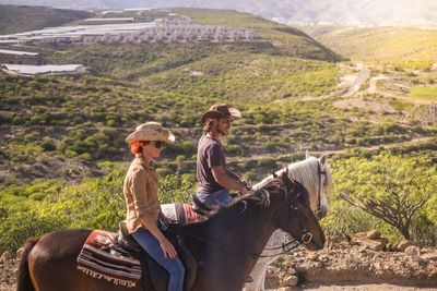 Friends riding horses on mountain