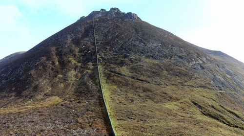 Low angle view of rocky mountain against sky