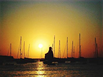 Sailboat sailing in sea at sunset