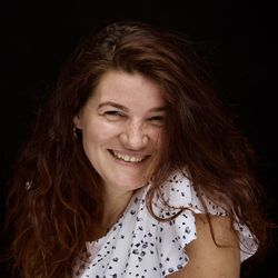 Portrait of smiling woman against black background