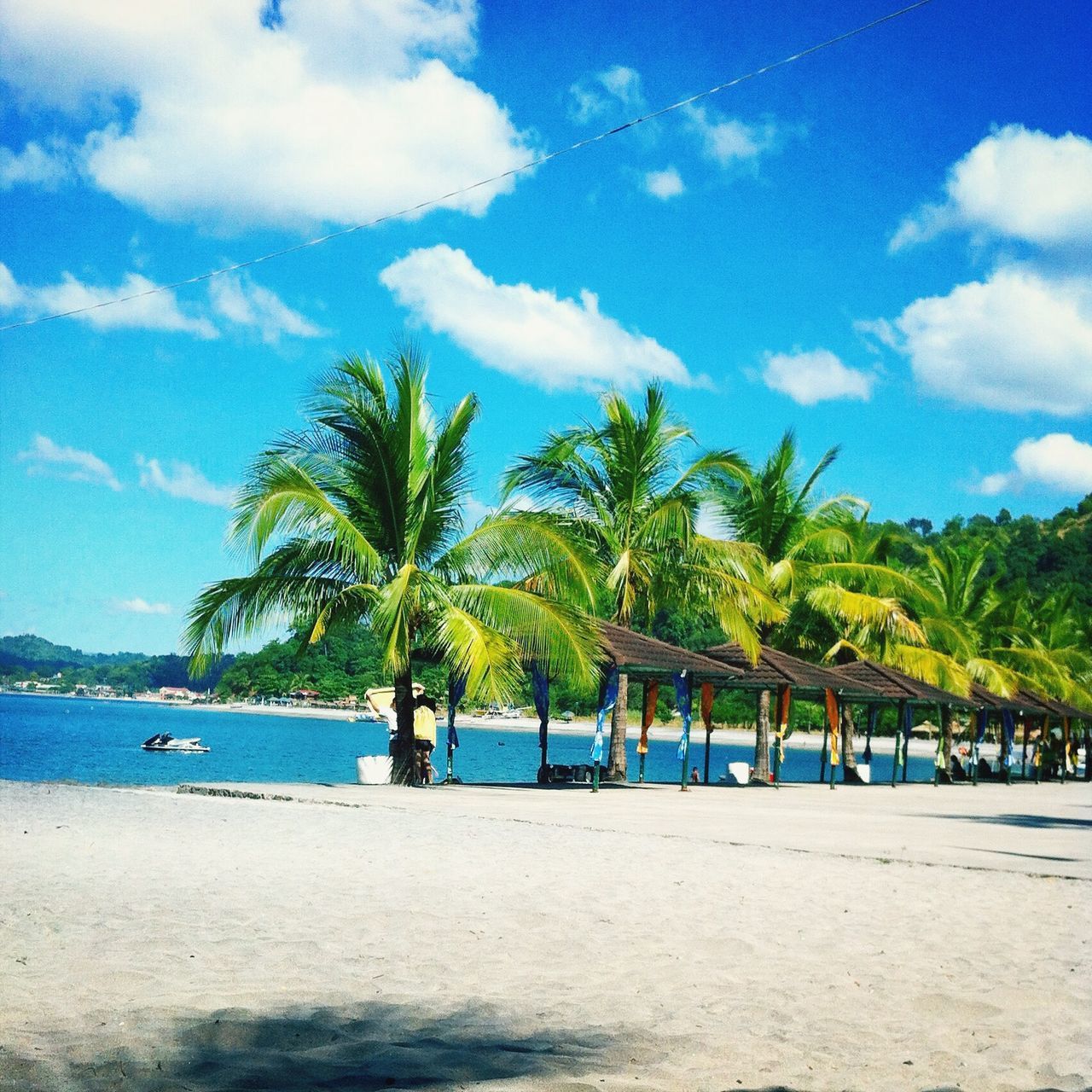 tree, beach, palm tree, water, sea, sky, tranquility, tranquil scene, sand, scenics, shore, beauty in nature, nature, blue, cloud - sky, vacations, cloud, idyllic, incidental people, growth