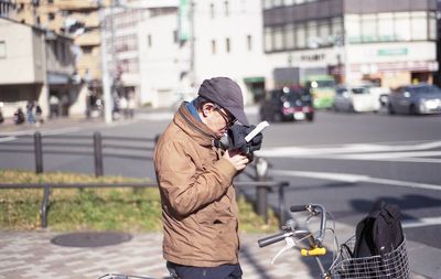 Man photographing with umbrella standing on street