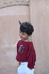 Girl standing against red wall