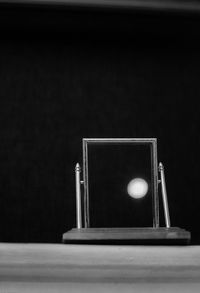 Close-up of camera on table against black background