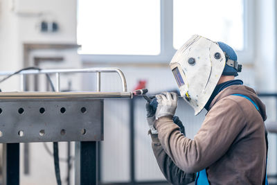 Rear view of man working in factory