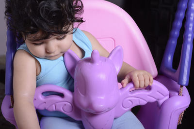 Low angle view of girl sitting on purple