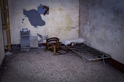 Abandoned chairs on table against wall in old building