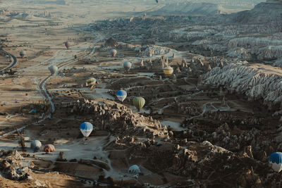 High angle view of hot air balloons over dramatic landscape