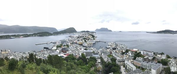 High angle view of city by sea against sky