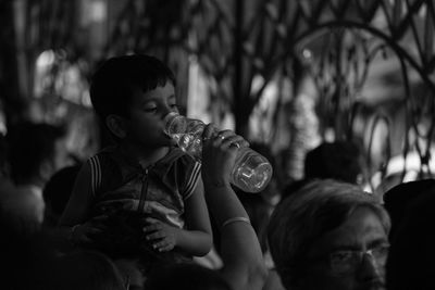 Mother feeding son water from bottle