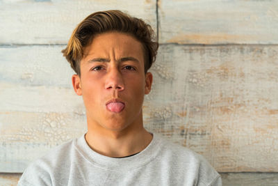 Close-up portrait of teenage boy against wall