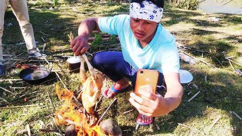 Young man using mobile phone on field