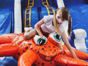 A little girl playing with bright toy in amusement park