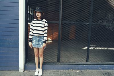 Portrait of woman standing against  wall