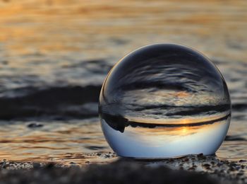 Close-up of crystal ball on beach