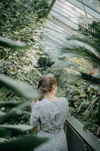 Rear view of woman standing by plants