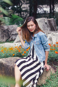 Beautiful young woman standing against plants