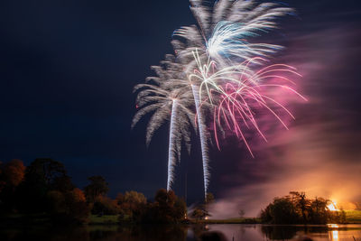 Low angle view of fireworks against sky at night